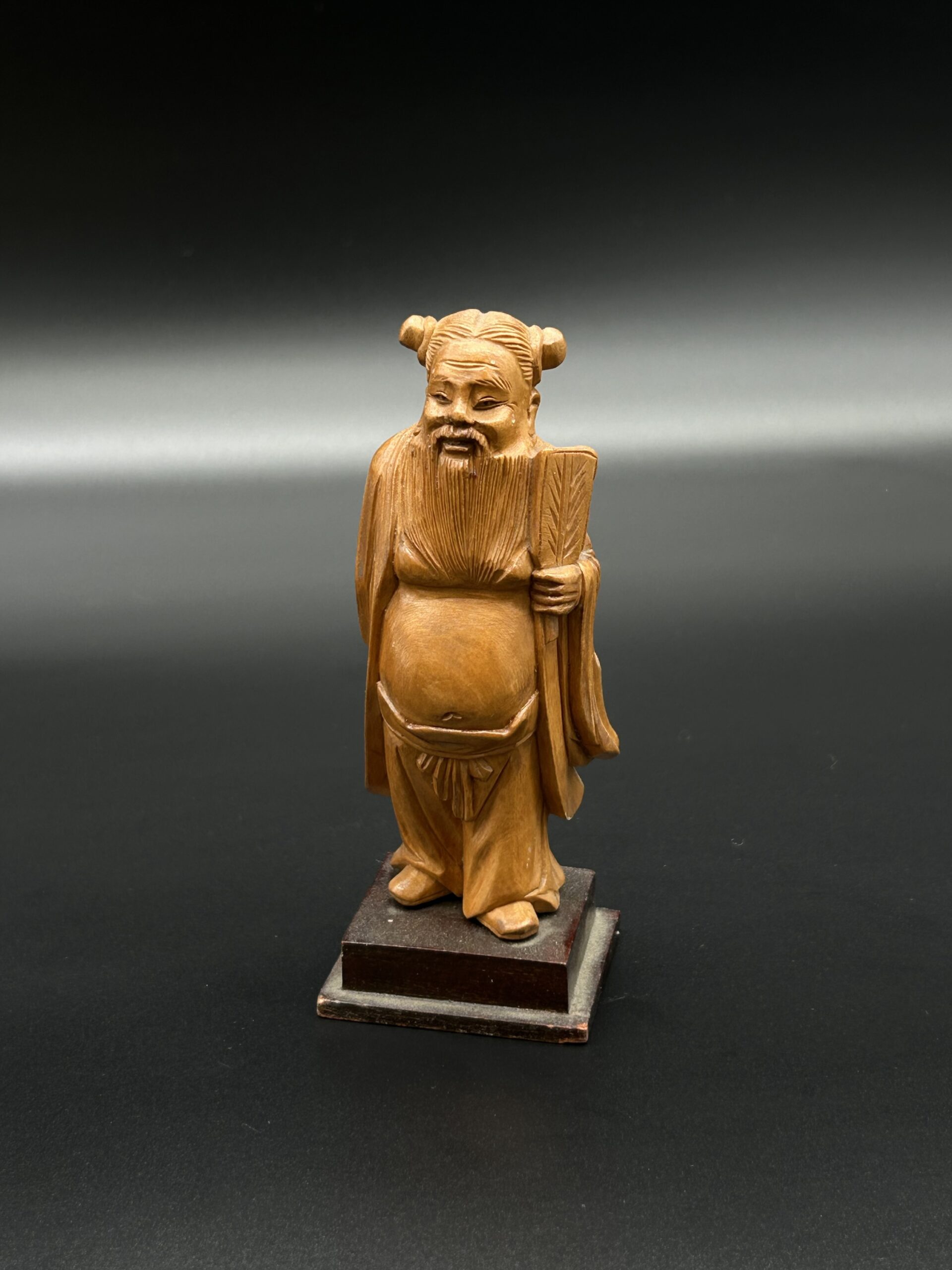 Drewniana figurka mędrca z wachlarzem